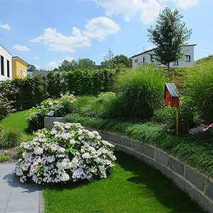 Kleine Stützmauer aus bruchrauen Granitsteinen