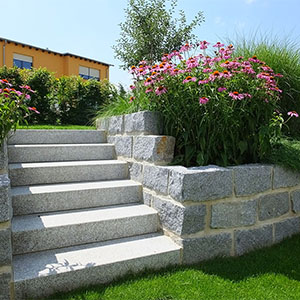 Eine Treppenanlage aus Granitblockstufen führt in die obere Gartenebene